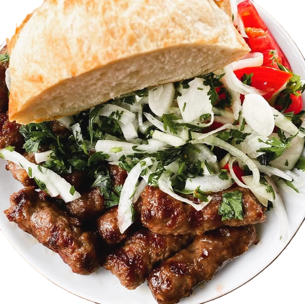 Ekmek, soğan, maydanoz ve domates eşliğinde servis edilen Biga köftesi.